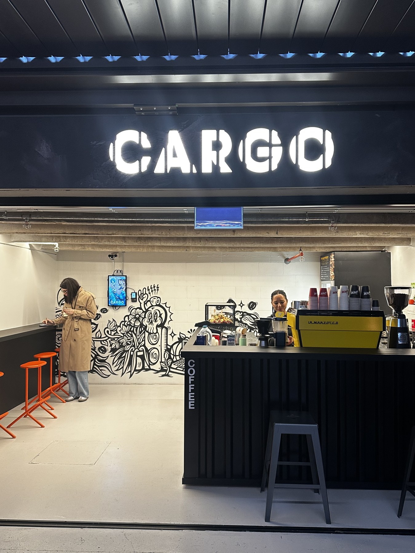 Cargo’s illuminated sign, barista and coffee counter